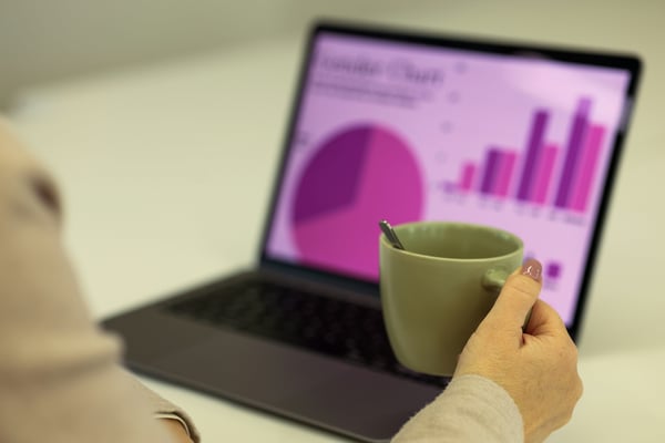 Property owner reviewing revenue charts and analytics on a laptop with a coffee cup nearby