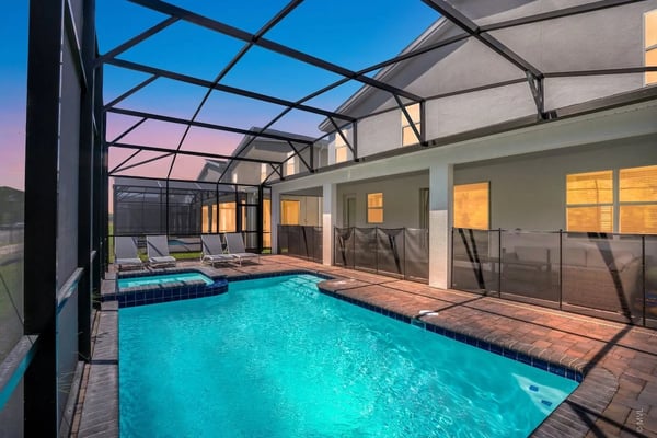 Screened pool and spa at a Kissimmee villa at dusk